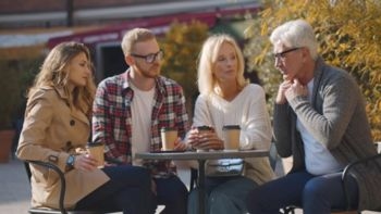Family having a serious discussion at an outdoor café, symbolizing the importance of clear estate planning to prevent costly probate disputes.