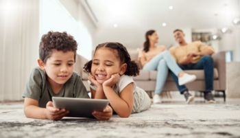 Parents siting on sofa and children watching
