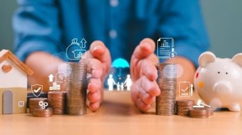 Hands protecting stacks of coins, with icons representing financial planning, family, insurance, and estate management, symbolizing the importance of minimizing family conflicts through smart estate planning.