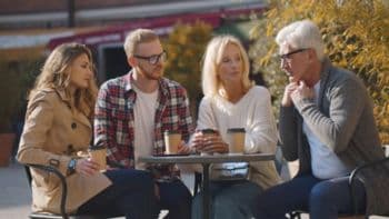 Family having a serious discussion at an outdoor café, symbolizing the importance of clear estate planning to prevent costly probate disputes.