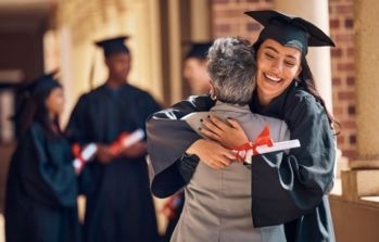 Graduate hugging a person at a graduation ceremony